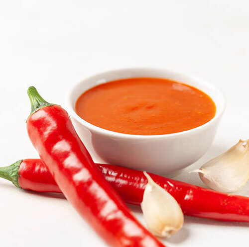 Freshly Sriracha Hot chilli Sauce in bowl on the table.